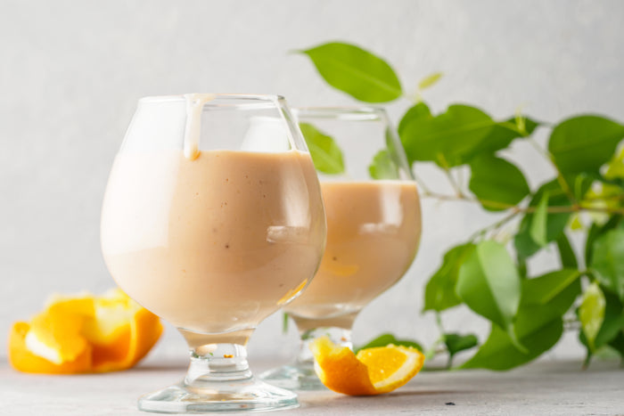 Frozen Orange Julius in two glasses with oranges around them.