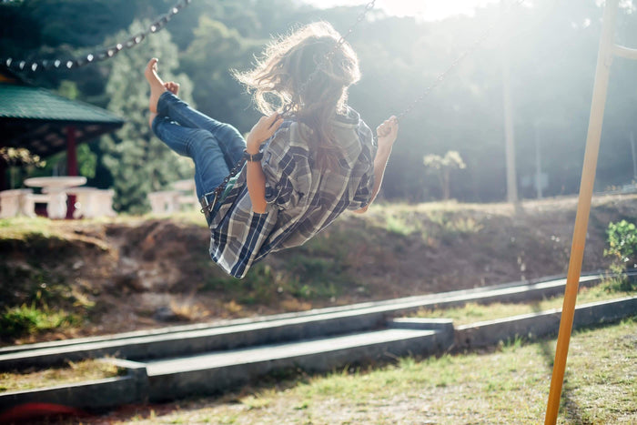 women on a swing in the summer sun