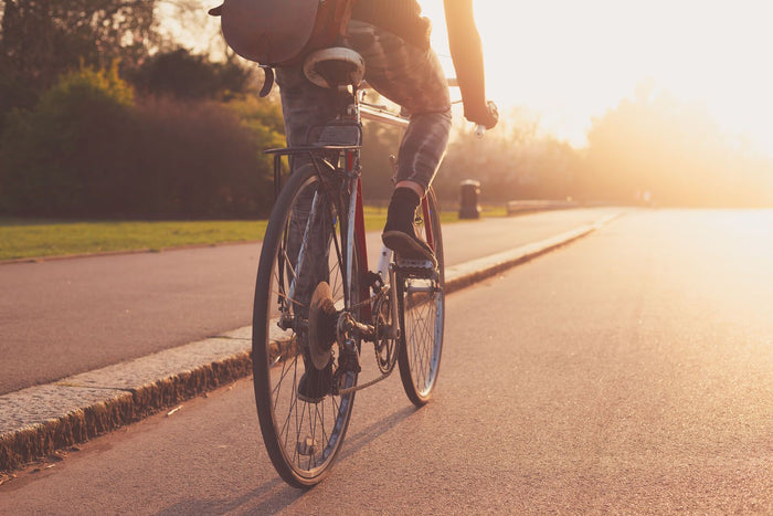 person rides bike during sunset