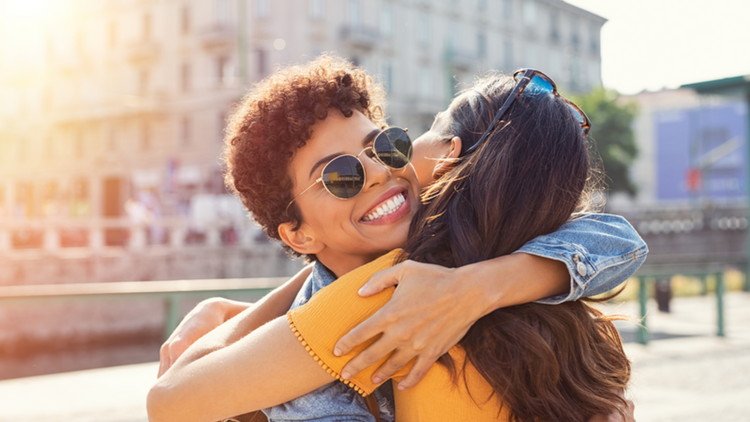 Two friends embracing in a warm hug. 