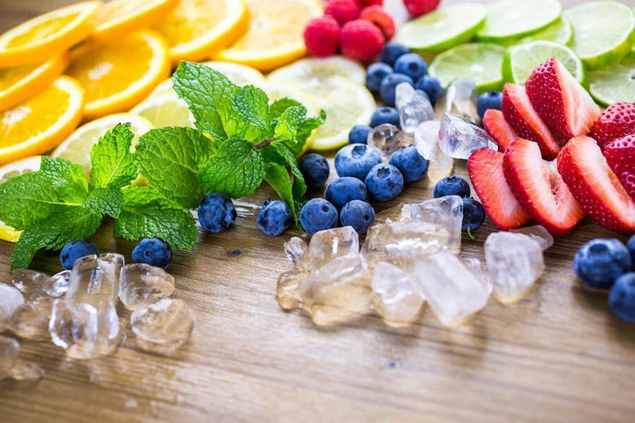 piles of blueberries strawberries mint and lemons