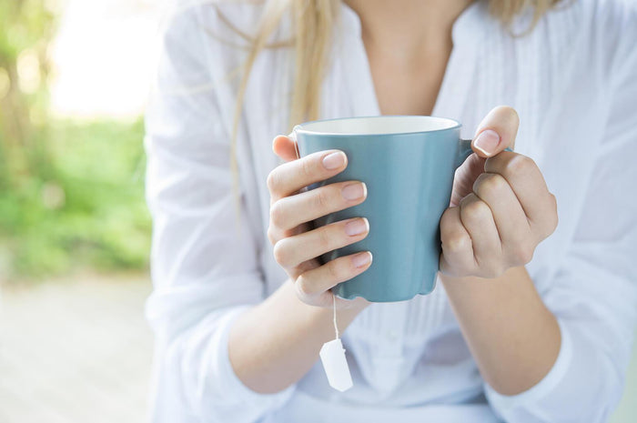 women holds a cup of warm tea