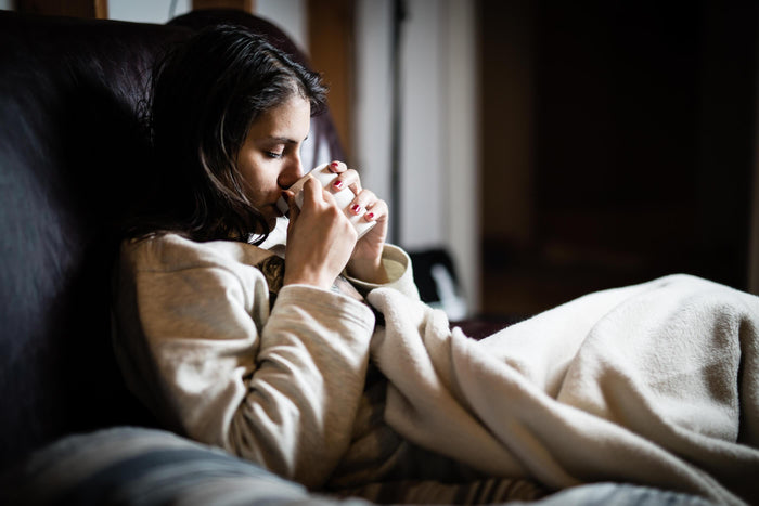 women sips tea in bed