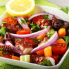 An octopus-leg salad with onions, tomatoes, and a dash of True Lemon Pepper Spice Blend.